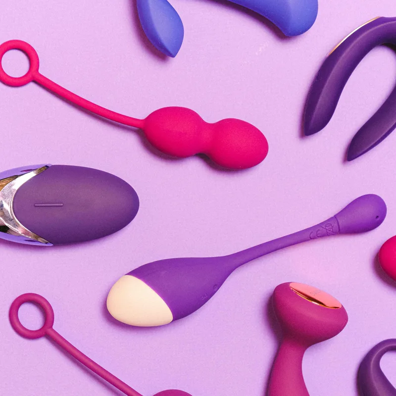 Huevo vibrador con cordón, bolas chinas y un mando plano sobre fondo lila